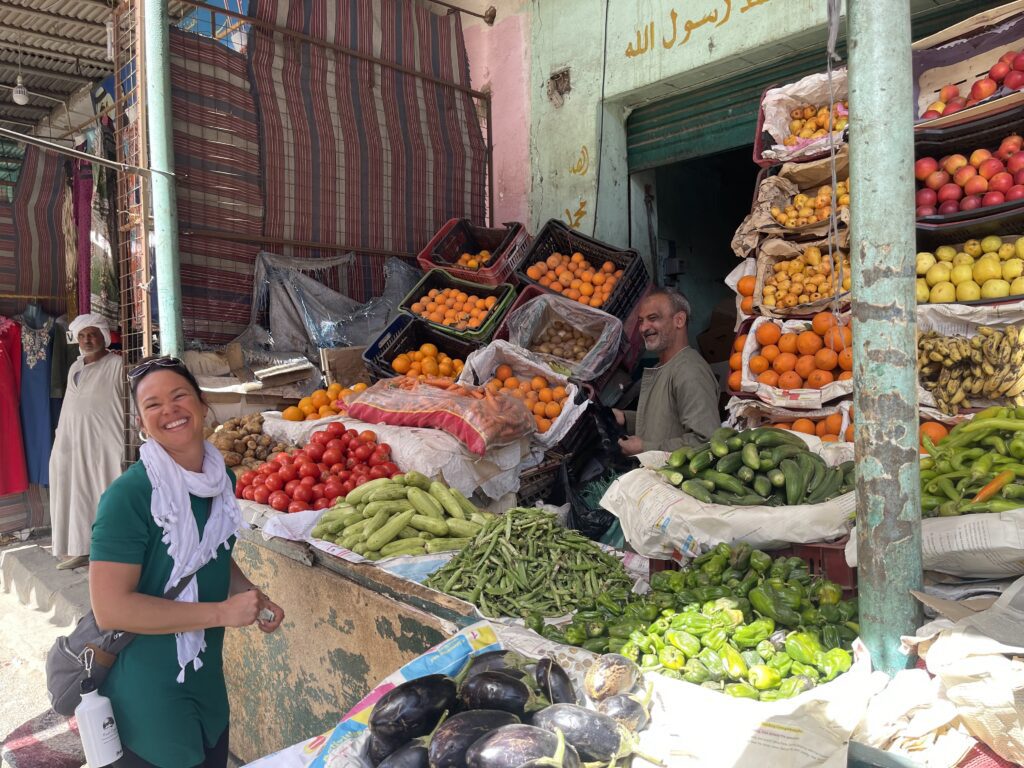 Happy guest picking out vegetables at Daraw market in Aswan
