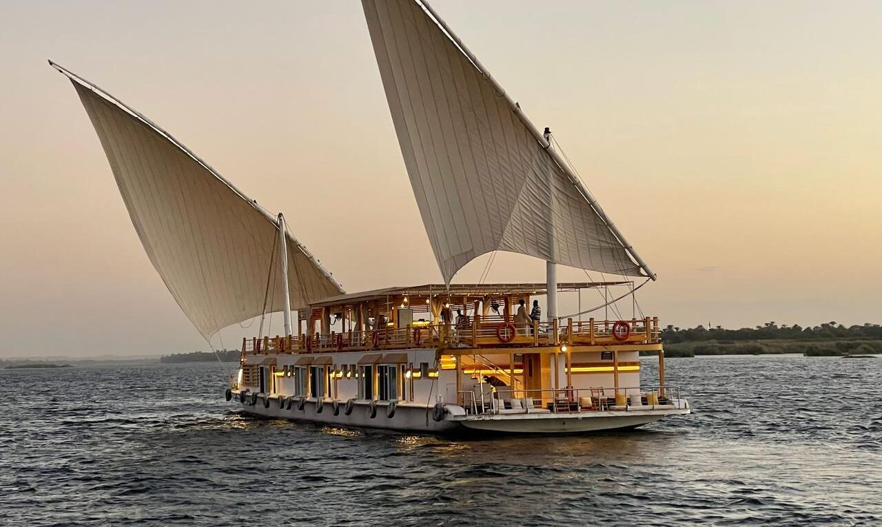 View from behind a dahabiya sailing in the middle the Nile River in Aswan, Egypt