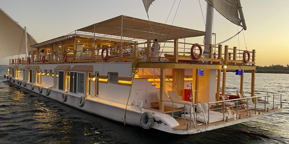 View from behind a dahabiya sailing along the Nile River in Aswan, Egypt